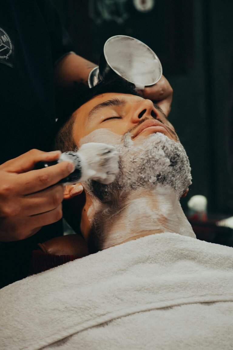 A man receiving a relaxing shave with foam at a barber shop.